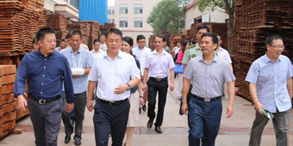 明堂红木总经理张向荣（左一）向东阳市政府领导介绍明堂红木情况